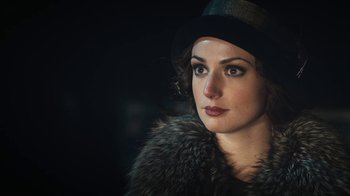 Movie still from “Peaky Blinders” (2013), created by Steven Knight – A woman wearing a fur coat and a hat; Close Up shot, Over the shoulder angle