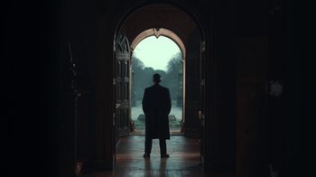 Movie still from “Peaky Blinders” (2013), created by Steven Knight – A man standing in front of an arched doorway; Wide shot, Low angle