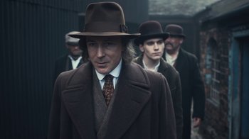 Movie still from “Peaky Blinders” (2013), created by Steven Knight – A group of men wearing hats and coats; Close Up shot, Low angle