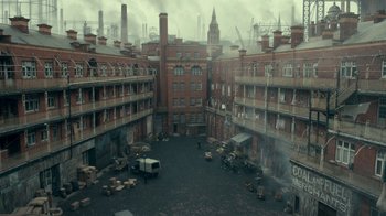 Movie still from “Peaky Blinders” (2013), created by Steven Knight – An industrial area with a lot of buildings and people; Extreme Wide shot, High angle