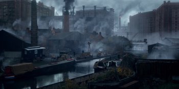 Movie still from “Peaky Blinders” (2013), created by Steven Knight – An industrial area with a river and buildings; Extreme Wide shot, High angle