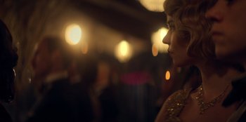 Movie still from “Peaky Blinders” (2013), created by Steven Knight – A woman in a gold dress looking at a crowd; Close Up shot, Over the shoulder angle