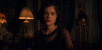 Movie still from “Peaky Blinders” (2013), created by Steven Knight – A woman in a black dress is looking at the camera; Close Up shot, Low angle