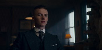 Movie still from “Peaky Blinders” (2013), created by Steven Knight – A man in a suit and tie in front of a window; Close Up shot, Low angle