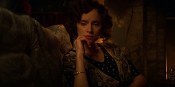 Movie still from “Peaky Blinders” (2013), created by Steven Knight – A woman sitting in a chair with her hand on her chin; Close Up shot, High angle