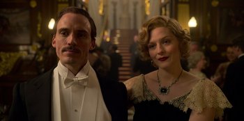 Movie still from “Peaky Blinders” (2013), created by Steven Knight – A man and a woman standing next to each other; Close Up shot, Low angle