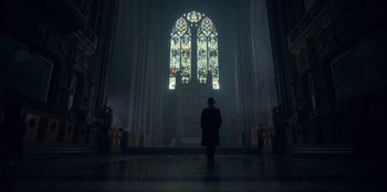 Movie still from “Peaky Blinders” (2013), created by Steven Knight – A man standing in front of a stained - glass window; Extreme Wide shot, Low angle