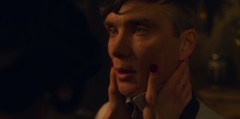 Movie still from “Peaky Blinders” (2013), created by Steven Knight – A person wearing a suit and tie; Close Up shot, Over the shoulder angle