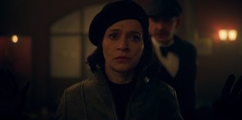 Movie still from “Peaky Blinders” (2013), created by Steven Knight – A woman wearing a black hat and a black jacket; Close Up shot, Over the shoulder angle