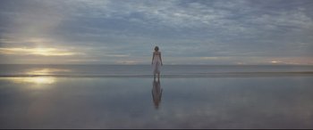 Movie still from “Penguin Bloom” (2020), directed by Glendyn Ivin – A woman standing on the beach looking out at the ocean; Extreme Wide shot, Low angle