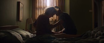 Movie still from “Penguin Bloom” (2020), directed by Glendyn Ivin – A man and a woman sitting on top of a bed; Medium shot, Low angle