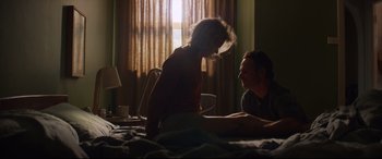 Movie still from “Penguin Bloom” (2020), directed by Glendyn Ivin – A man and a woman sitting on top of a bed in a room; Medium shot, Over the shoulder angle