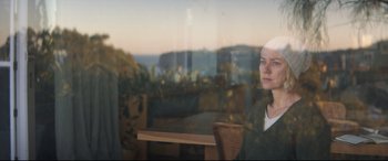 Movie still from “Penguin Bloom” (2020), directed by Glendyn Ivin – A woman sitting at a table looking out of a window; Close Up shot, Over the shoulder angle