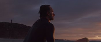 Movie still from “Penguin Bloom” (2020), directed by Glendyn Ivin – A man standing on top of a beach at sunset; Close Up shot, Low angle