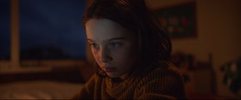 Movie still from “Penguin Bloom” (2020), directed by Glendyn Ivin – A young girl is sitting in a dark room; Close Up shot, Low angle