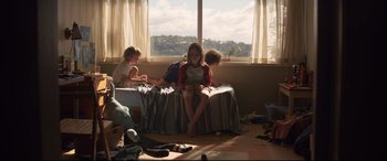 Movie still from “Penguin Bloom” (2020), directed by Glendyn Ivin – Three children sitting on a bed in front of a large window; Wide shot, High angle