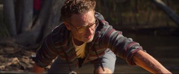 Movie still from “Penguin Bloom” (2020), directed by Glendyn Ivin – A man with glasses is riding a skateboard; Close Up shot, Over the shoulder angle