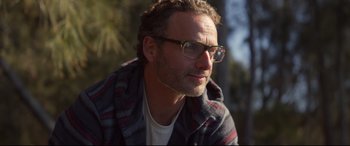 Movie still from “Penguin Bloom” (2020), directed by Glendyn Ivin – A person wearing glasses and a plaid shirt; Close Up shot, Over the shoulder angle