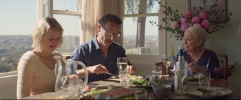 Movie still from “Penguin Bloom” (2020), directed by Glendyn Ivin – A man sitting at a table with a plate of food; Medium shot, Over the shoulder angle