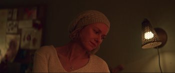 Movie still from “Penguin Bloom” (2020), directed by Glendyn Ivin – A woman wearing a sweater and a hat is looking down; Close Up shot, Over the shoulder angle