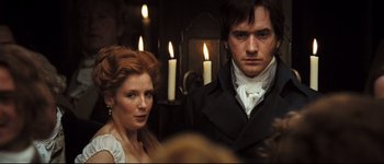 Movie still from “Pride & Prejudice” (2005), directed by Joe Wright – A man and a woman standing next to each other in front of candles; Close Up shot, Over the shoulder angle