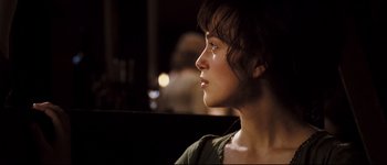Movie still from “Pride & Prejudice” (2005), directed by Joe Wright – A young woman looking off into the distance in the dark; Close Up shot, Over the shoulder angle