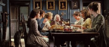 Movie still from “Pride & Prejudice” (2005), directed by Joe Wright – A group of people sitting around a table with food on top of it; Wide shot, High angle