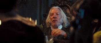Movie still from “Pride & Prejudice” (2005), directed by Joe Wright – An older man sitting in a chair with a candle in front of him; Close Up shot, Over the shoulder angle