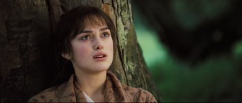 Movie still from “Pride & Prejudice” (2005), directed by Joe Wright – A young woman is looking into the distance while standing next to a tree; Close Up shot, High angle