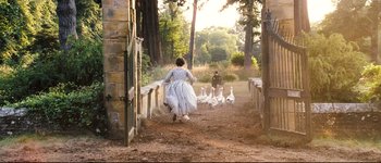 Movie still from “Pride & Prejudice” (2005), directed by Joe Wright – A woman in a blue dress and a man in a brown suit are walking with geese; Wide shot, High angle