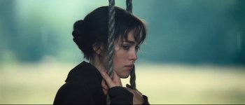 Movie still from “Pride & Prejudice” (2005), directed by Joe Wright – A young woman holding a rope on top of a swing; Close Up shot, High angle