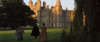 Movie still from “Pride & Prejudice” (2005), directed by Joe Wright – Two people are walking in front of an old castle; Extreme Wide shot, High angle