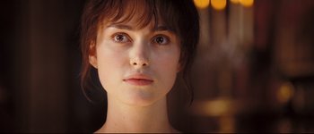 Movie still from “Pride & Prejudice” (2005), directed by Joe Wright – A woman's face in a dimly - lit room; Close Up shot, Over the shoulder angle