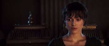 Movie still from “Pride & Prejudice” (2005), directed by Joe Wright – A person wearing a black shirt near a piano; Close Up shot, Over the shoulder angle