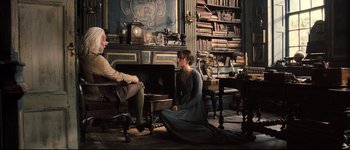 Movie still from “Pride & Prejudice” (2005), directed by Joe Wright – A man and a woman sitting on a chair in front of a fireplace; Wide shot, High angle