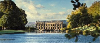 Movie still from “Pride & Prejudice” (2005), directed by Joe Wright – A large building sitting on the side of a lake; Extreme Wide shot, Low angle