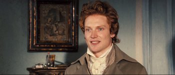 Movie still from “Pride & Prejudice” (2005), directed by Joe Wright – A young man with long red hair wearing a coat and tie; Close Up shot, Over the shoulder angle