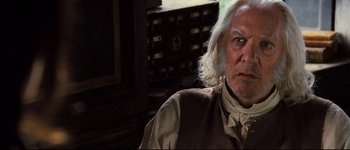 Movie still from “Pride & Prejudice” (2005), directed by Joe Wright – An older man with long white hair and a beard; Close Up shot, Over the shoulder angle