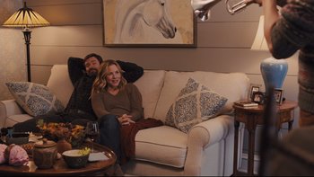 Movie still from “Prisoners” (2013), directed by Denis Villeneuve – A man and a woman sitting on a white couch; Wide shot, High angle