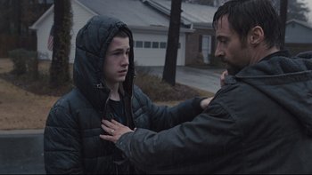 Movie still from “Prisoners” (2013), directed by Denis Villeneuve – A man helping a young boy with a hoodie; Medium shot, Over the shoulder angle