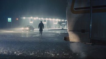 Movie still from “Prisoners” (2013), directed by Denis Villeneuve – A man walking in the rain at night near an airport; Wide shot, Low angle