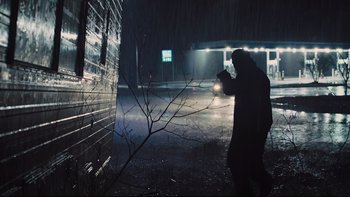 Movie still from “Prisoners” (2013), directed by Denis Villeneuve – A person is standing in the dark holding a flashlight; Wide shot, Low angle