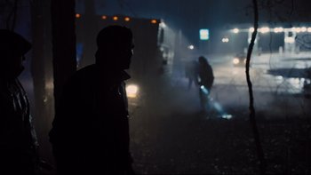 Movie still from “Prisoners” (2013), directed by Denis Villeneuve – A man standing on the side of a road at night; Wide shot, Over the shoulder angle