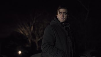 Movie still from “Prisoners” (2013), directed by Denis Villeneuve – A man wearing a black jacket standing in the dark; Medium shot, Over the shoulder angle