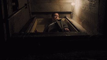 Movie still from “Prisoners” (2013), directed by Denis Villeneuve – A man in a suit and tie in an elevator; Wide shot, Low angle