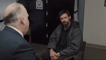 Movie still from “Prisoners” (2013), directed by Denis Villeneuve – A man sitting in front of another man in a room; Medium shot, Over the shoulder angle
