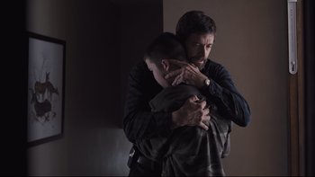 Movie still from “Prisoners” (2013), directed by Denis Villeneuve – A man and a boy hugging in a dark room; Medium shot, Low angle