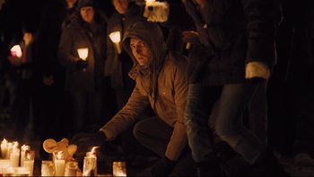 Movie still from “Prisoners” (2013), directed by Denis Villeneuve – A man kneeling down in front of a group of people; Medium shot, Over the shoulder angle