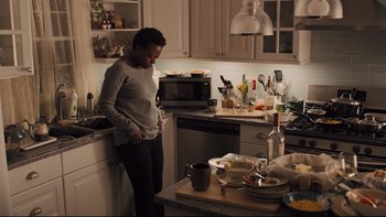 Movie still from “Prisoners” (2013), directed by Denis Villeneuve – A woman standing in a kitchen next to a counter; Medium shot, High angle