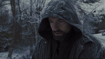 Movie still from “Prisoners” (2013), directed by Denis Villeneuve – A man with a beard wearing a hooded jacket in the snow; Close Up shot, Low angle